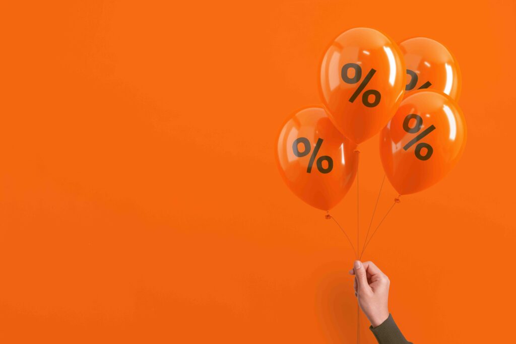 Set of orange balloons with black percent sign floating on orange background. Sale, discount and marketing concept.