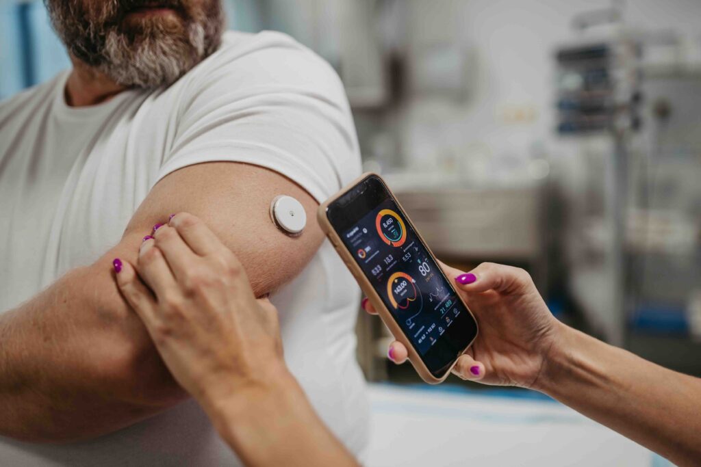 Close up of woman hands using lancet on finger to check blood sugar level by Glucose meter using as Medicine, diabetes, glycemia, health care and people concept.