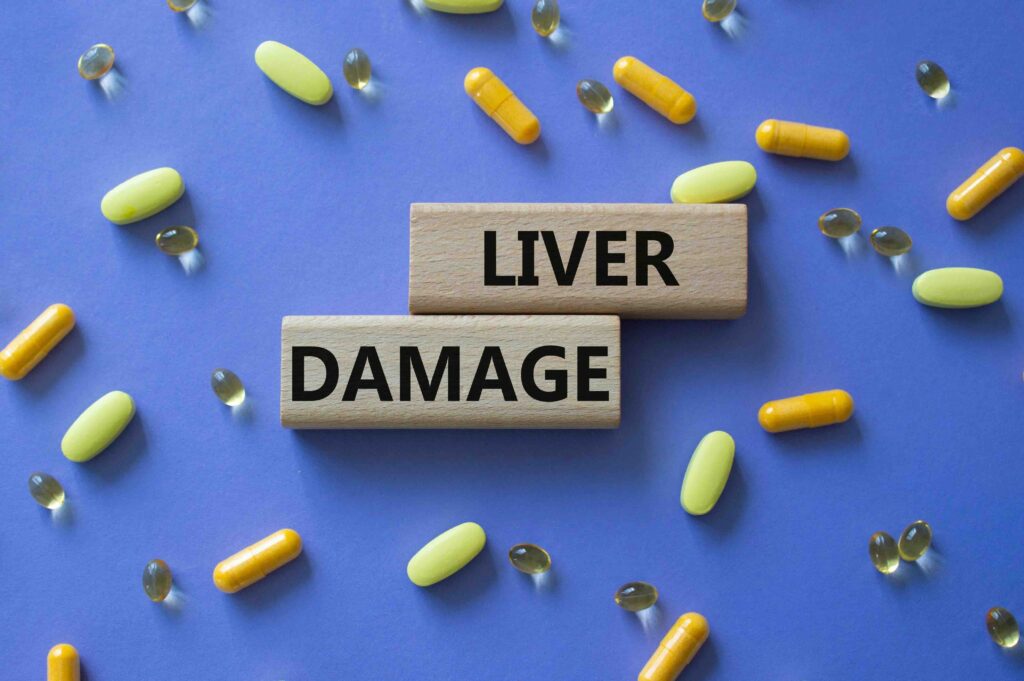 Liver Damage symbol. Concept word Liver Damage on wooden blocks. Beautiful purple background with pills. Medicine and Liver Damage concept. Copy space